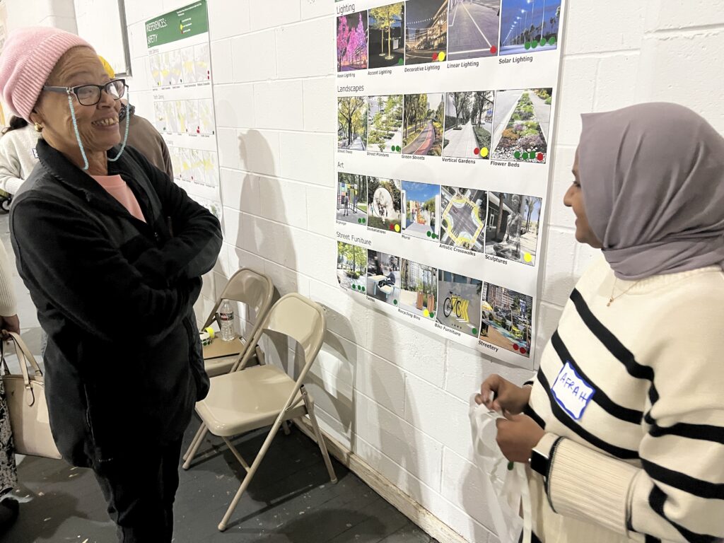 Two people talking in front of a poster