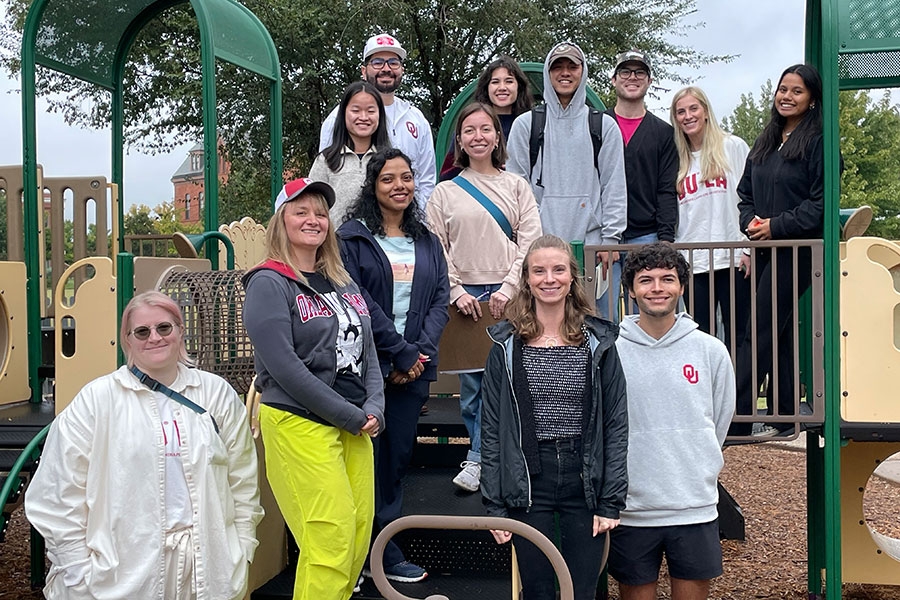 A group of young adults standing on playground equipment.